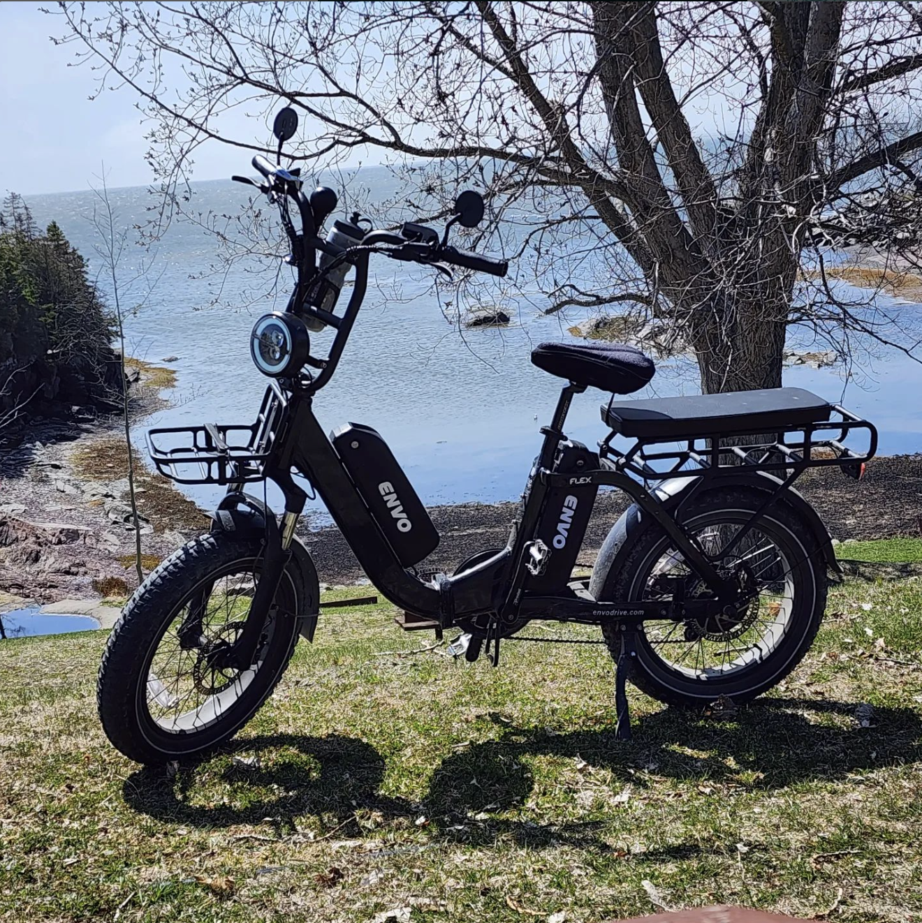 Envo Flex Overland folding cargo electric bicycle on grass near a lake.