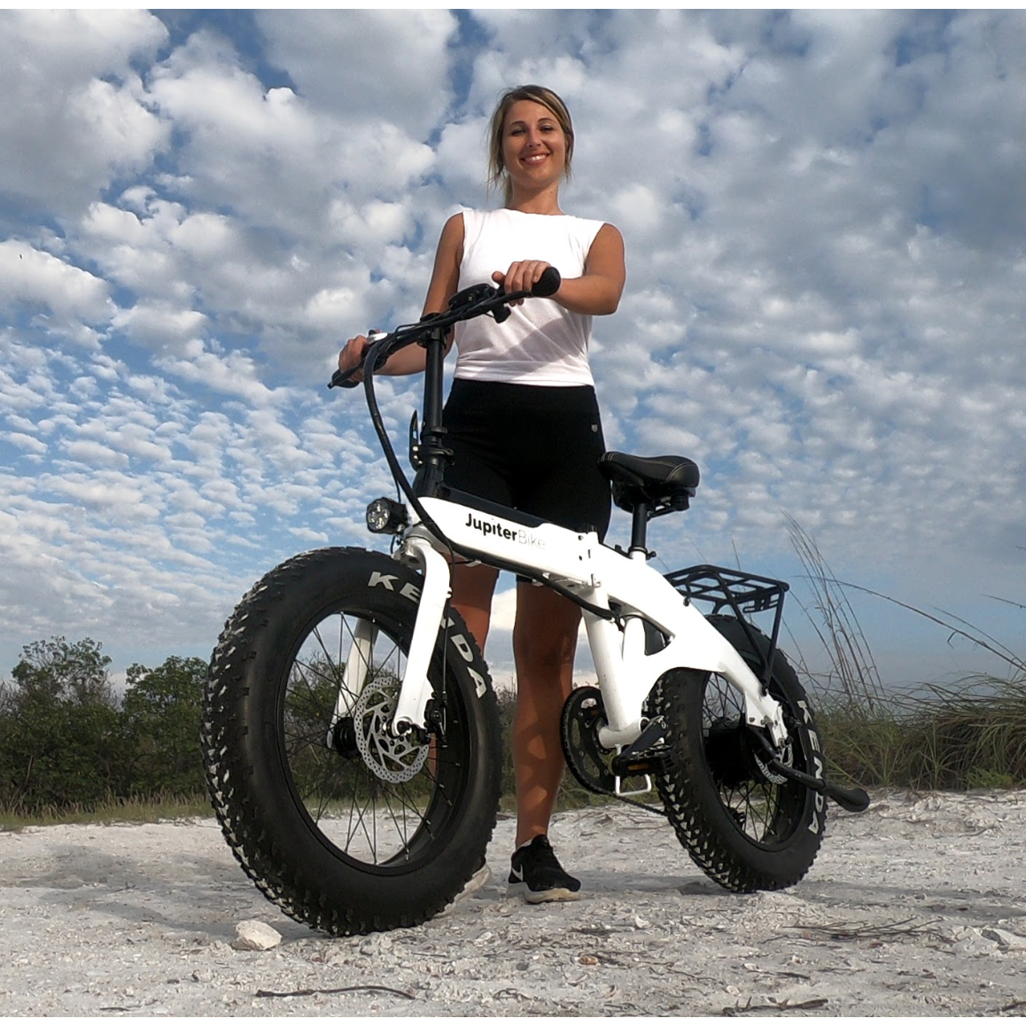 Girl with Jupiter Defiant fat tire folding ebike on beach.