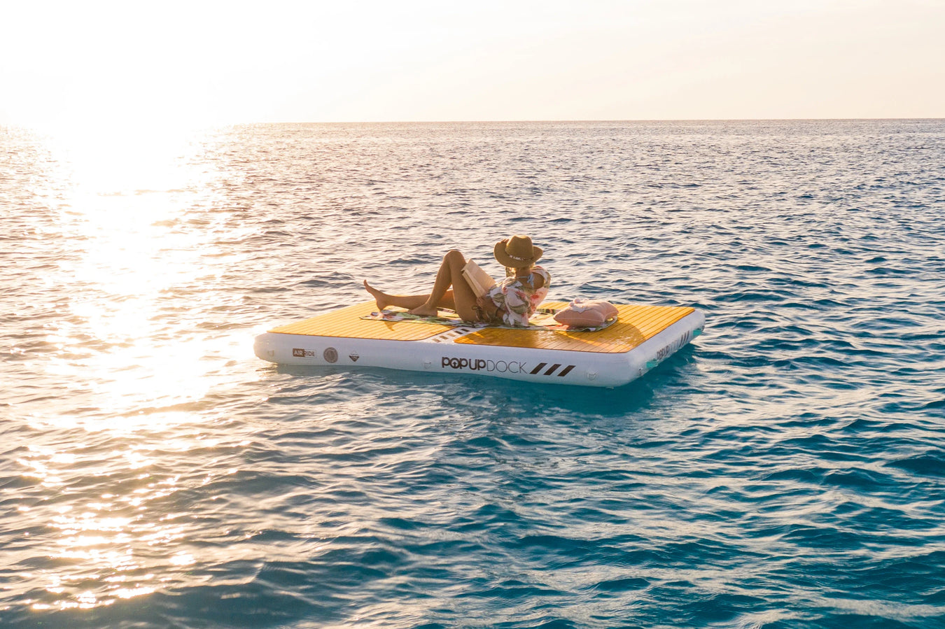 Girl on inflatable dock floating on water. 