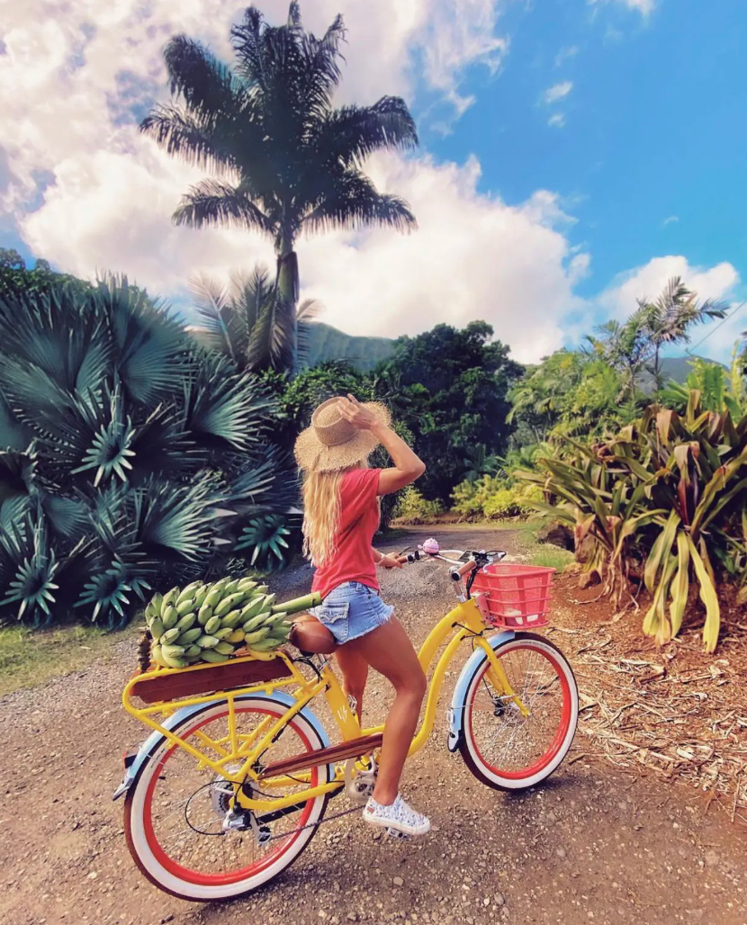 Girl on step-thru ebike in tropical setting.