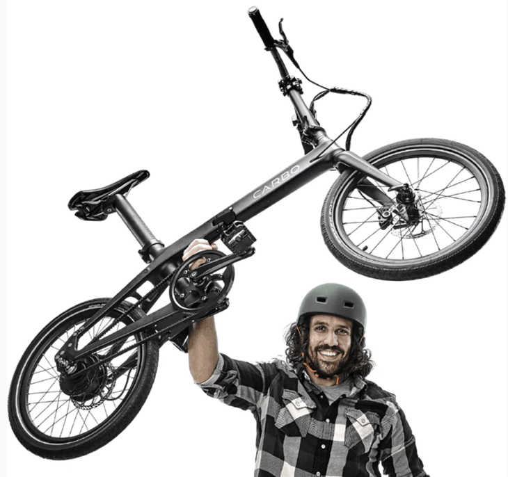 Guy holding Carbo lightweight electric bike above his head with one hand.