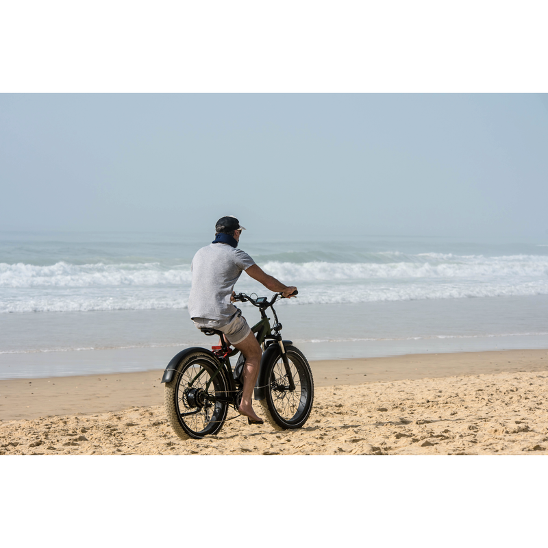 Man riding electric bike on the beach. 