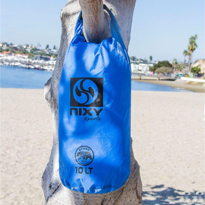 NIXY Dry Sack 10 Liter Hanging From Tree Branch On Beach