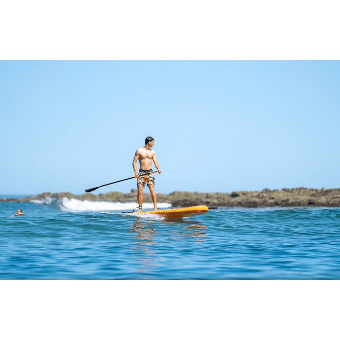 Guy standing on Aqua Marina Fusion SUP in water. 