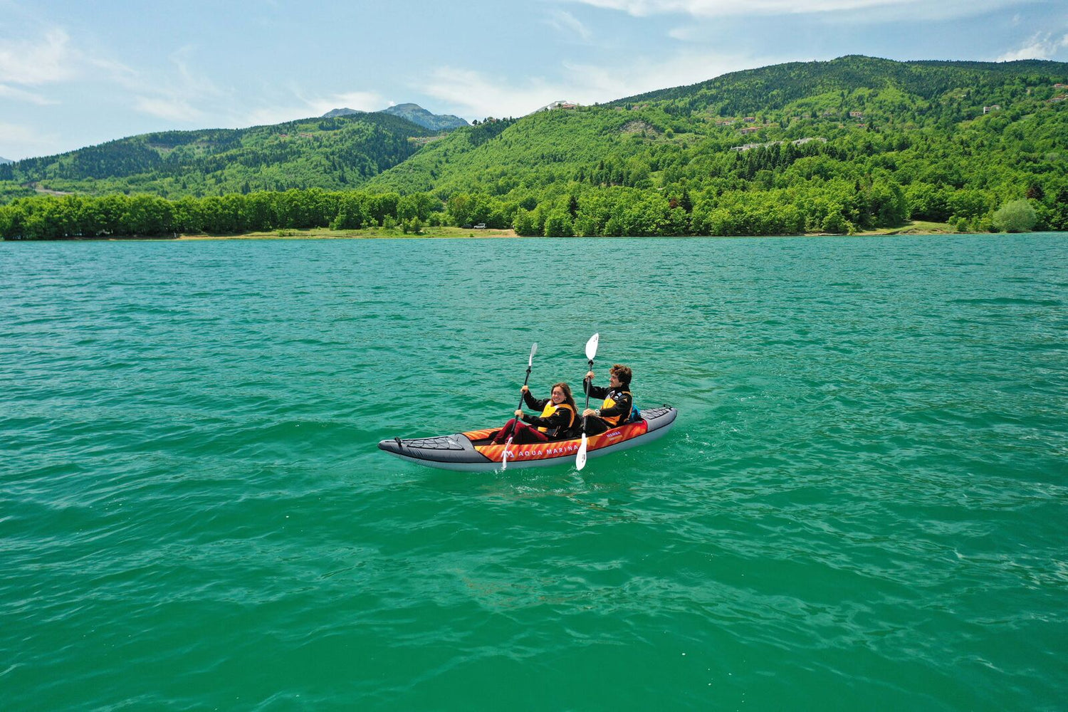 Couple paddling Aqua Marina Memba 12'10" 2 seat inflatable kayak on a lake.