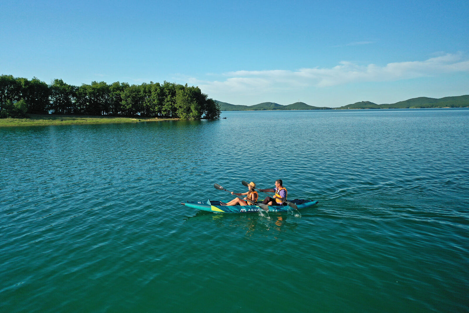 Couple paddling Aqua Marina Steam Inflatable Kayak on lake. 