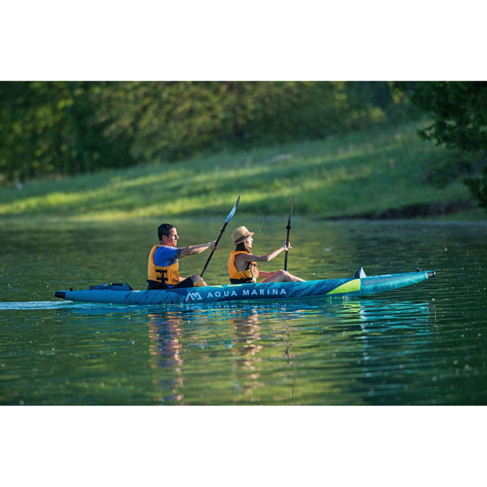 Couple paddling Aqua Marina Steam inflatable kayak on lake.