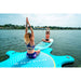 Aqua Marina Inflatable Yoga Dock with SUP connected, girls arm stretch pose. 