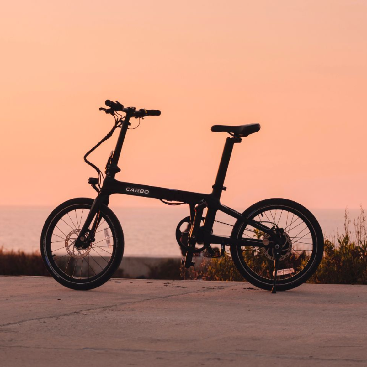 The CARBO Model X eBike parked on concrete at sunset.