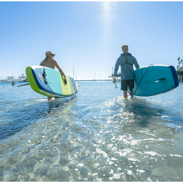Girl carrying a Jimmy Styks Neptune iSUP into the water with a guy carrying his own.