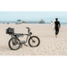 Electric Bike Company Model J on a beach with surfboard rack and carton on it.