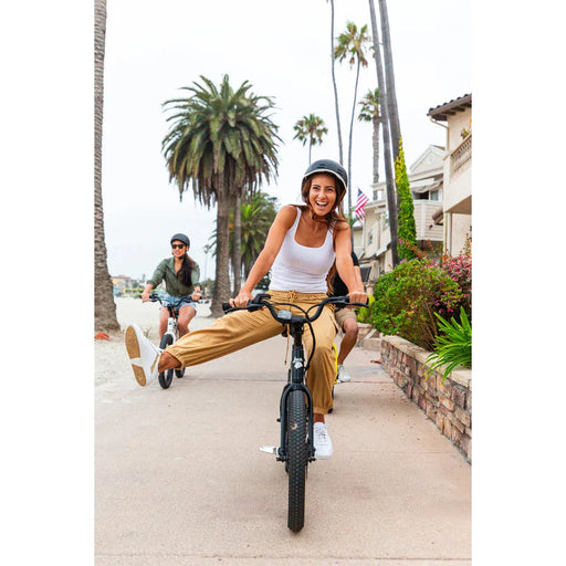 Girl being funny with leg extended to her right side while riding a JackRabbit e-Bike.