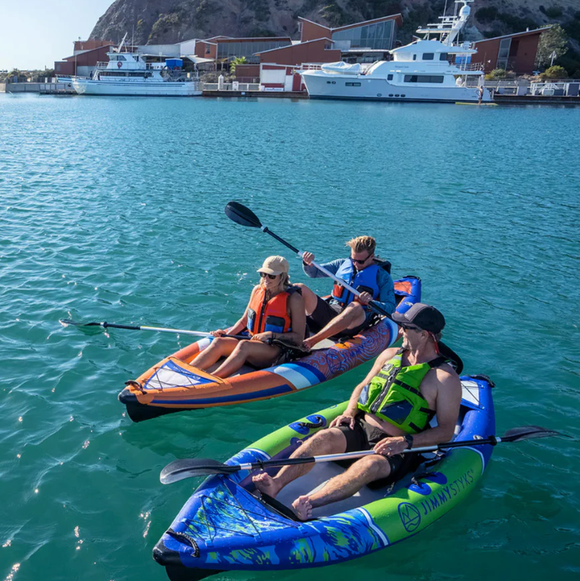 Guy in his Nomad I paddling with friends on the water in their own kayak.