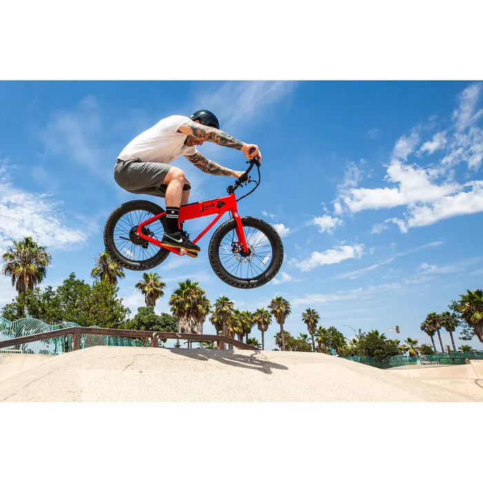 Guy in the air riding a red JackRabbit XG with shorts on and Nike sneakers.