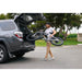 Man carrying JackRabbit MG Renegade electric bicycle out of an open SUV trunk on a street.