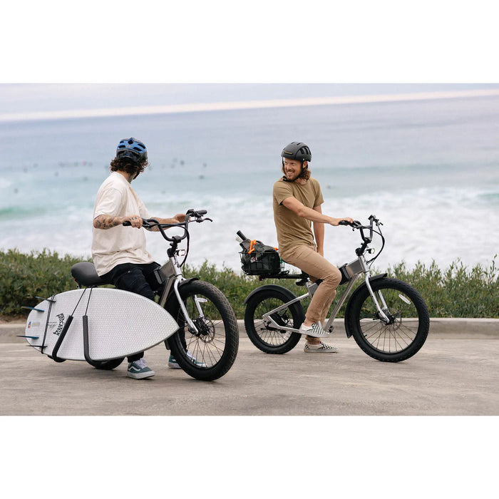 Two people with JackRabbit MG Renegade electric bikes by the beach.