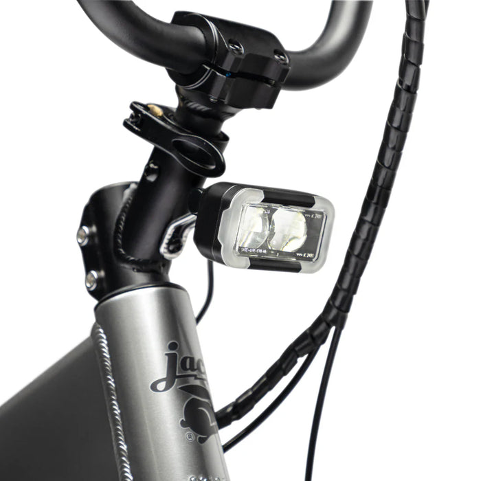 Close-up of a JackRabbit Renegade electric bicycle handlebar with a light attached, with the JackRabbit logo.