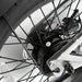 Close-up of a JackRabbit MG Renegade electric bike wheel with a gear and chain mechanism on a white background.