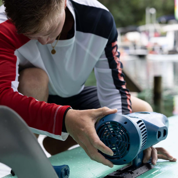 Boy attaching the Jimmy Styks Boost Seascooter to the bottom of the Jimmy Styks Nomad II Inflatable Kayak.