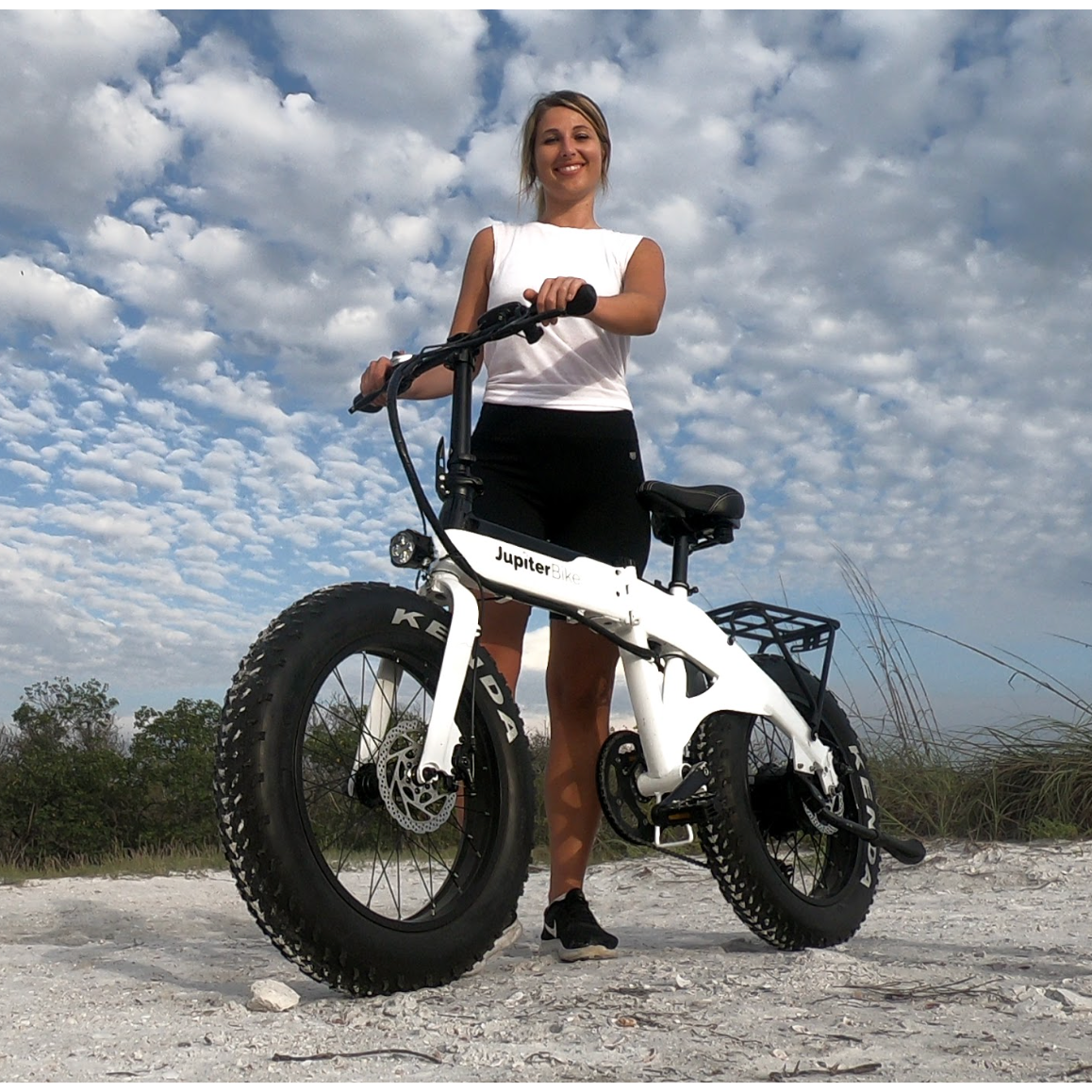 Girl with Jupiter Defiant fat tire folding ebike on beach. 