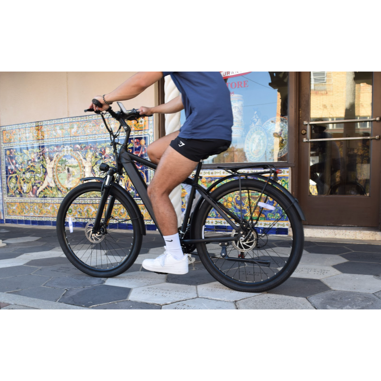 Guy riding in city on Jupiter Tempo Electric Bike. 