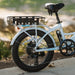 White electric bike with a black basket on a blurred natural background