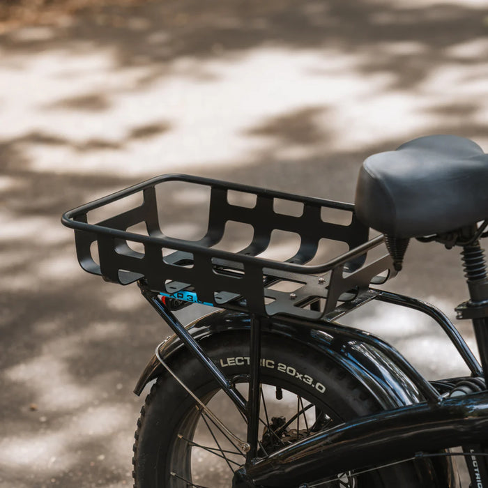 Black Lectric XP 3.0 electric bicycle with a rear basket on a blurred natural background
