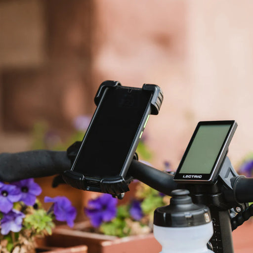 Lectric Phone Mount installed on handlebars with violets in background.