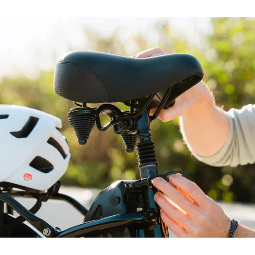 Lifestyle photo of the Lectric Step-Thru Comfort Package on a bike with a white helmet sitting on rear rack next to it.