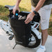 Man putting something in a Lectric Waterproof Pannier Bag on side of white XP 3.0.