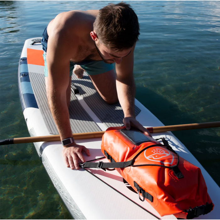 Guy on iSUP looking at phone in Loon Paddle Company's Dry Bag.