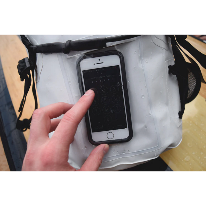 Person using their cell phone through the front access pocket of the Loon Paddle Company 15L Dry Bag.