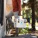 Man carrying Lectric Hard Cooler into front door of house.