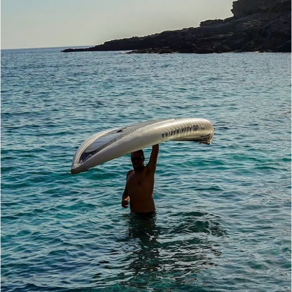 Man carrying the Aqua Marina Halve Kayak above his head with one hand while standing in the water.