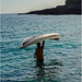Man carrying the Aqua Marina Halve Kayak above his head with one hand while standing in the water.
