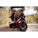 Man picking up a folded red HOVSCO HovBeta Electric Bike to put in the back of his vehicle.