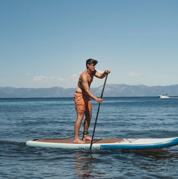 Male paddling out on the water on a Dax Board Co. Dax Air Seagull iSUP.