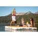 Two girls sitting on the POP Dock with a guy doing a handstand.