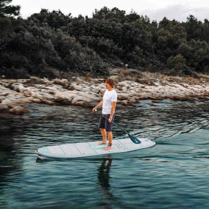 Guy paddle boarding on the shore line on a SipaBoards Drive Neo Silver Stand Up Paddle Board.