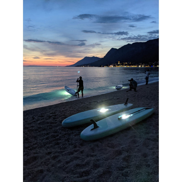 SipaBoards Drive Tourer Aqua iSUP on the beach at night lit up.