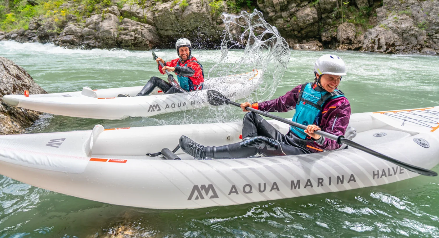 Two people in separate Aqua Marina Halve Inflatable Kayaks playing in the water while taking a break from paddling.