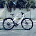 Urtopia Carbon 1 Pro eBike in a parking lot with a white fence and palm trees in the background.