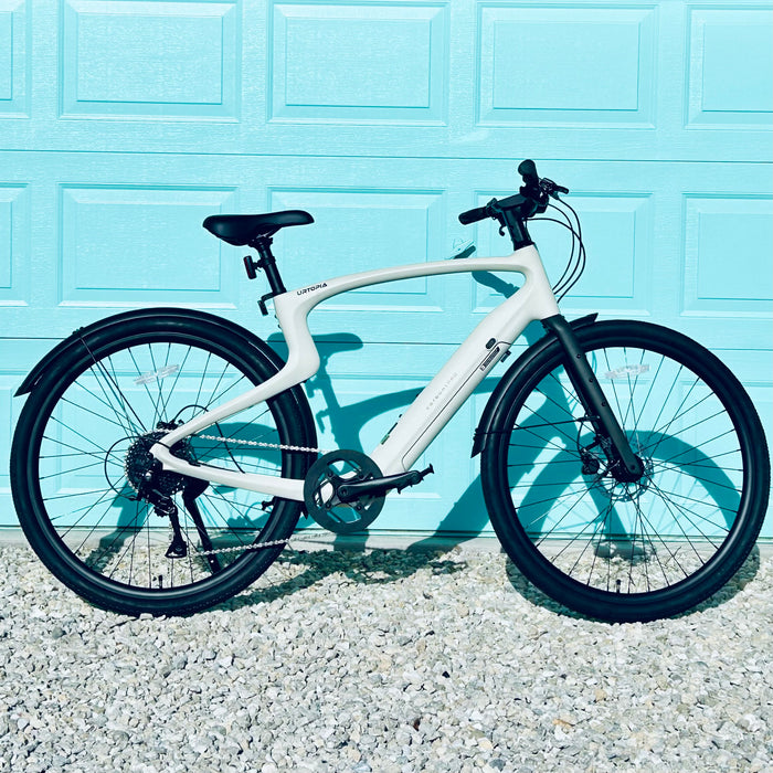 Urtopia Carbon 1 Pro eBike parked against a light blue garage door background.