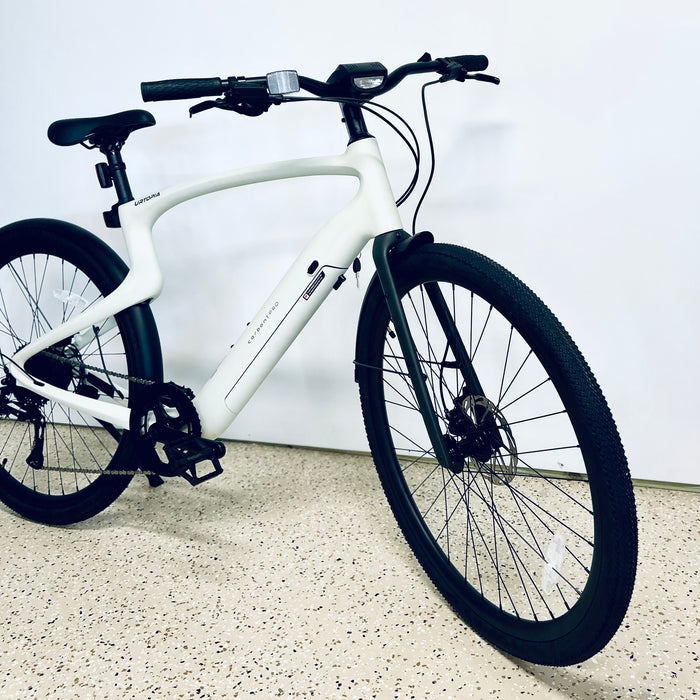 Urtopia Carbon 1 Pro eBike front end on a light gray floor against a white wall.
