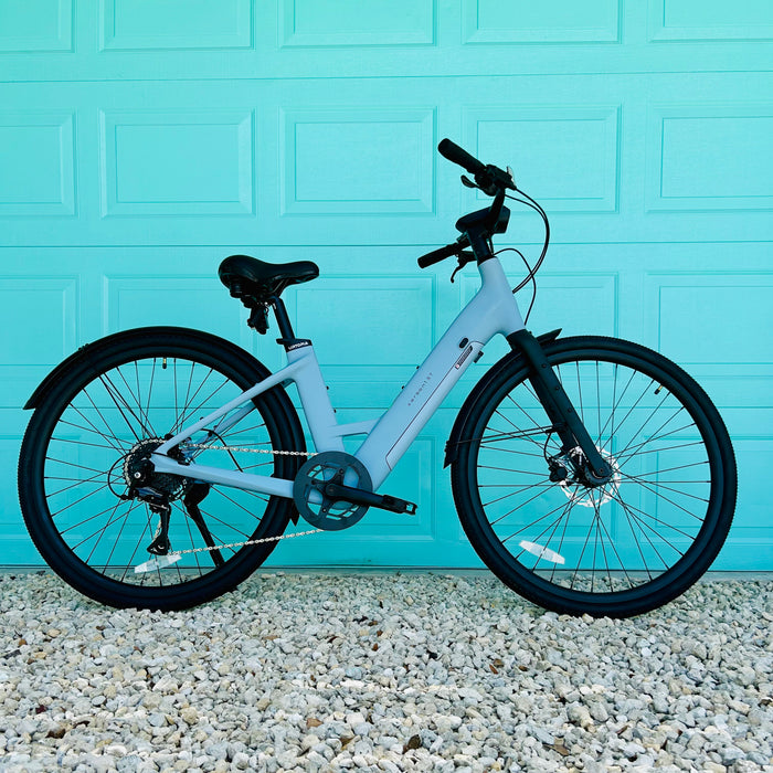 Urtopia Carbon ST Glacier Blue ebike parked in front of aqua colored door. 