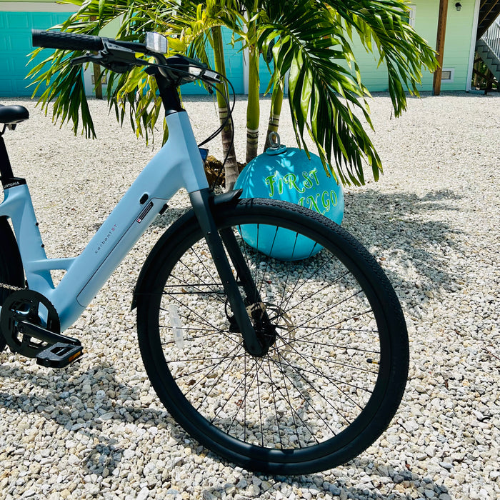 Urtopia Carbon ST ebike's front tire parked outside Fort Myers Beach rental house First Mango.