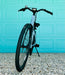 Front view of the Urtopia Carbon ST Glacier Blue ebike parked in front of aqua colored door. 