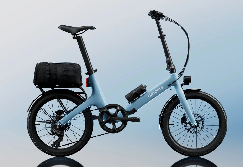 An Urtopia Carbon Fold ST electric bike on a light blue background with a water bottle and trunk bag installed.