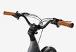 Close-up of an Urtopia Joy Carbon's handlebars with leather grips on a white background