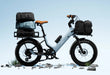 Urtopia Joy Carbon e-bike in glacier blue with cargo bags on a clear blue sky background